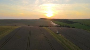 Buğday tarlasında hasat mevsiminde çalışan hasat makinesinin hava görüntüsü. Tarım kavramı.