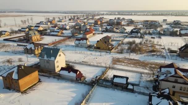 冬に郊外の農村部で屋根が雪で覆われた住宅の空中ビュー — ストック動画