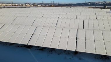 Kar, temiz elektrik enerjisi üretmek için birçok sıra güneş fotovoltaik paneliyle sürdürülebilir elektrik santralini kapladı. Kışın yenilenebilir elektriğin düşük etkisi.