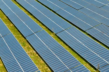 Temiz elektrik enerjisi üretmek için birçok sıra güneş fotovoltaik paneli bulunan sürdürülebilir büyük elektrik santralinin havadan görünüşü. Sıfır emisyon kavramı ile yenilenebilir elektrik.