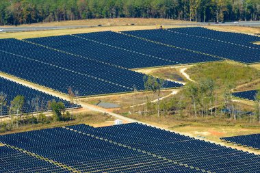 Temiz elektrik enerjisi üretmek için birçok sıra güneş fotovoltaik paneli bulunan sürdürülebilir büyük elektrik santralinin havadan görünüşü. Sıfır emisyon kavramı ile yenilenebilir elektrik.