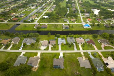 Florida 'nın sakin yerleşim bölgesinde yeşil palmiye ağaçları arasında özel evleri olan küçük bir Amerikan banliyö manzarası..