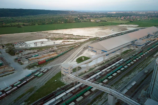 Aerial view of cargo train cars loaded with construction goods at mining factory. Railway transportation of industrial production raw materials.
