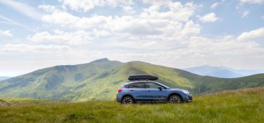 Blue off road car on mountain trail. Traveling by auto, adventure in wildlife, expedition or extreme travel on SUV automobile.