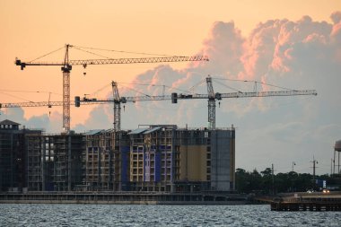 Tower lifting cranes at high residential apartment buildings construction site. Real estate development.
