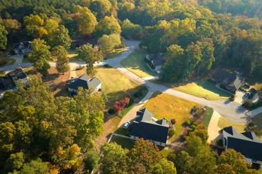 Güney Carolina 'nın banliyölerindeki sarı sonbahar ağaçları arasındaki pahalı konutların manzarası. Amerikan banliyölerinde emlak gelişimine örnek olarak Amerikan rüya evleri.