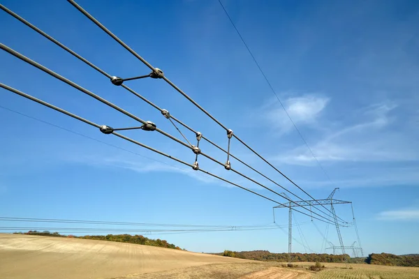 Stock image High voltage power line with insulation divider of electric power wires for safe delivering of electrical energy through steel cable on long distance.