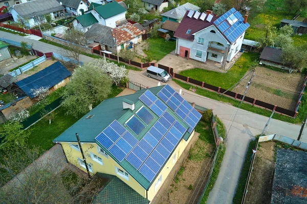 Private home roof covered with solar photovoltaic panels for generating of clean ecological electric energy in suburban rural town area. Concept of autonomous house.