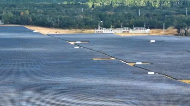 Temiz elektrik enerjisi üretmek için birçok sıra güneş fotovoltaik paneli bulunan sürdürülebilir büyük elektrik santralinin havadan görünüşü. Sıfır emisyon kavramı ile yenilenebilir elektrik.