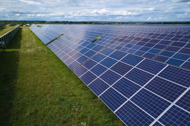Temiz elektrik enerjisi üretmek için sıra sıra güneş fotovoltaik panelleri olan sürdürülebilir büyük elektrik santralinin havadan görünüşü. Sıfır emisyonlu yenilenebilir elektrik kavramı.