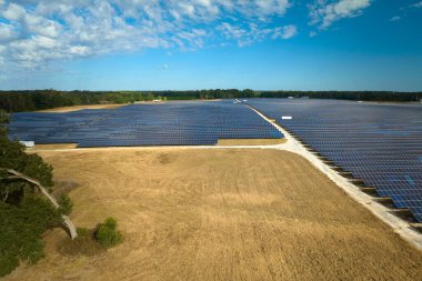 Temiz elektrik enerjisi üretmek için sıra sıra güneş fotovoltaik panelleri olan sürdürülebilir büyük elektrik santralinin havadan görünüşü. Sıfır emisyonlu yenilenebilir elektrik kavramı.