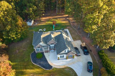 Güney Carolina 'nın banliyö bölgesindeki sarı sonbahar ağaçları arasındaki pahalı konutların manzarası. Amerikan banliyölerinde emlak gelişimine örnek olarak Amerikan rüya evi.