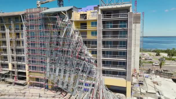 高いアパートの建物のサイト上のハリケーンイアン建設足場によって破壊されたの空中ビュー — ストック動画