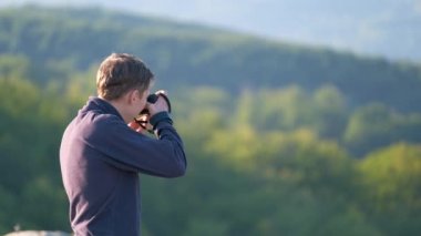 Yürüyüş fotoğrafçısı yaz dağlarında sabah doğasının fotoğraflarını çekiyor..