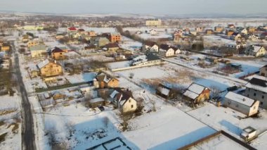 Kışın kırsal kesimde, banliyöde karla kaplı çatıları olan yerleşim yerlerinin hava manzarası..