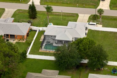 Florida 'nın sakin kırsal kesimindeki yeşil palmiye ağaçları arasındaki banliyö özel evlerinin hava manzarası.