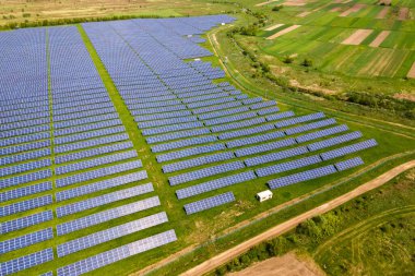 Temiz ekolojik elektrik enerjisi üretmek için birçok sıra güneş fotovoltaik paneli bulunan sürdürülebilir büyük elektrik santralinin havadan görünüşü. Sıfır emisyon kavramı ile yenilenebilir elektrik.