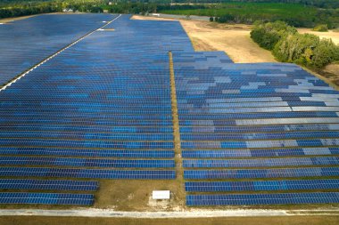 Temiz elektrik enerjisi üretmek için birçok sıra güneş fotovoltaik paneli bulunan sürdürülebilir büyük elektrik santralinin havadan görünüşü. Sıfır emisyon kavramı ile yenilenebilir elektrik.