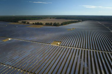 Temiz elektrik enerjisi üretmek için birçok sıra güneş fotovoltaik paneli bulunan sürdürülebilir büyük elektrik santralinin havadan görünüşü. Sıfır emisyon kavramı ile yenilenebilir elektrik.