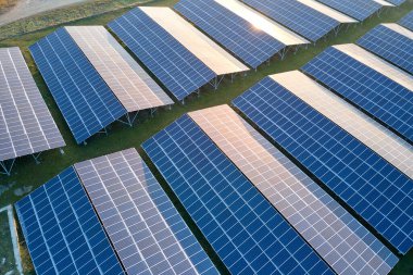 Temiz ekolojik elektrik enerjisi üretmek için sıra sıra güneş fotovoltaik panelleri olan sürdürülebilir büyük elektrik santralinin havadan görünüşü. Sıfır emisyon kavramı ile yenilenebilir elektrik