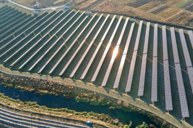 Temiz ekolojik elektrik enerjisi üretmek için sıra sıra güneş fotovoltaik panelleri olan sürdürülebilir büyük elektrik santralinin havadan görünüşü. Sıfır emisyon kavramı ile yenilenebilir elektrik.