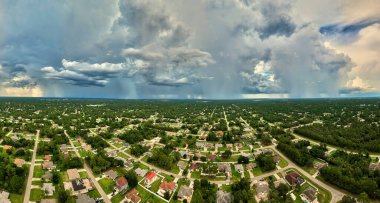 Landscape of dark ominous clouds forming on stormy sky during heavy thunderstorm over rural town area.