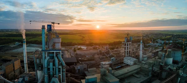Aerial view of cement factory with high concrete plant structure and tower crane at industrial production area. Manufacture and global industry concept.