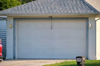 Geniş garaj, çift kapı ve modern Amerikan evinin beton yolu..