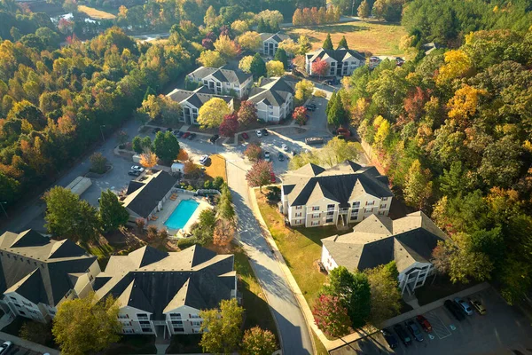 View from above of apartment residential condos between yellow fall trees in suburban area in South Carolina. American homes as example of real estate development in US suburbs.