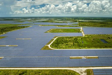 Temiz elektrik enerjisi üretmek için sıra sıra güneş fotovoltaik panelleri olan sürdürülebilir büyük elektrik santralinin havadan görünüşü. Sıfır emisyonlu yenilenebilir elektrik kavramı.