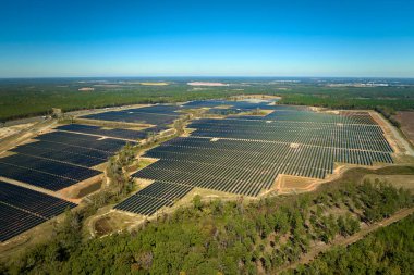 Temiz elektrik enerjisi üretmek için sıra sıra güneş fotovoltaik panelleri olan sürdürülebilir büyük elektrik santralinin havadan görünüşü. Sıfır emisyonlu yenilenebilir elektrik kavramı.