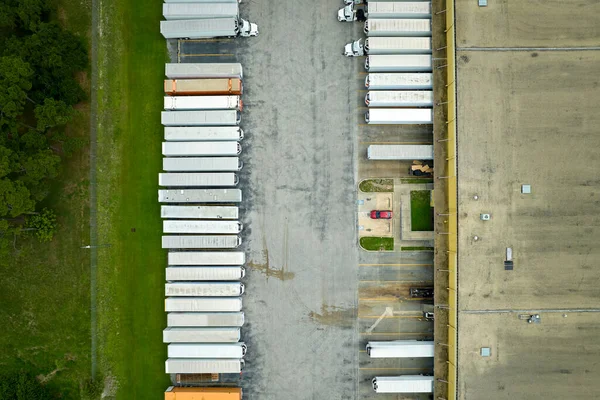 多くの貨物トラックを積み降ろし 更なる流通のための商品をアップロードする大規模な商業配送センターの高い角度ビュー 世界経済の概念 — ストック写真