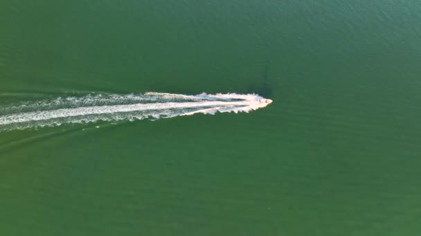 リップルの表面と海の波の上で速く泳ぐ白いスピードボートの空中ビュー 高速海上を航行中のモーターボート — ストック動画