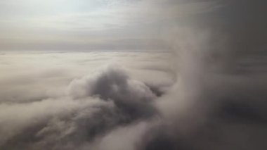 Dünya 'nın yüksek irtifasındaki uçak penceresinden hava manzarası beyaz kabarık kümülüs bulutlarıyla kaplı..