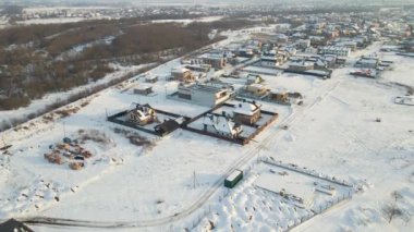 Kışın kırsal kesimde, banliyöde karla kaplı çatıları olan yerleşim yerlerinin hava manzarası..