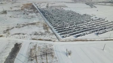 Aerial view of snow melting from covered solar photovoltaic panels at sustainable electric power plant for producing clean electrical energy. Low effectivity of renewable electricity in winter.