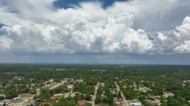 Dark stormy clouds forming on gloomy sky before heavy rainfall over suburban town area.