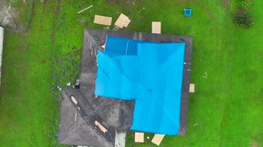 Ian Kasırgası, asfalt kiremitleri değişene kadar yağmur suyuna karşı koruyucu plastik muşambayla kaplı evin çatısına zarar verdi. Doğal afetten sonra.