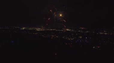 Aerial view of bright fireworks exploding with colorful lights over sea shore on US Independence day holiday.
