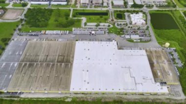 Ülke çapında dağıtım için perakende mal indiren ve yükleyen bir çok dağıtım kamyonuyla büyük ticari yükleme alanının havadan görüntüsü. Küresel ekonomi kavramı.