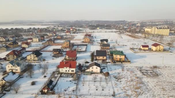 Ilmakuva Asuintaloista Lumen Peittämillä Katoilla Esikaupunkialueilla Maaseudulla Talvella — kuvapankkivideo