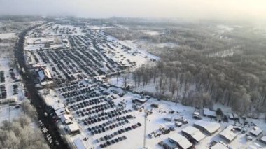 Açık pazar alanının hava manzarası. Satılık birçok araba park edilmiş ve insanlar kışın yürüyor..