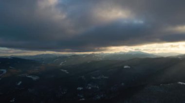 Soğuk ve sakin bir akşamda şiddetli kar yağışı sonrası dağ tepeleriyle kaplı kışın manzarası..