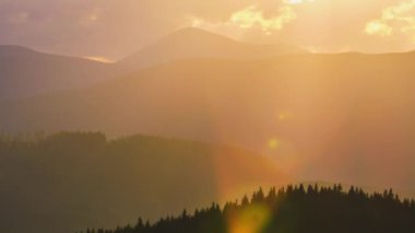 Güzel bir akşam panoramik manzarası. Gün batımında uzak dağ tepeleri üzerinde parlak batan güneş..