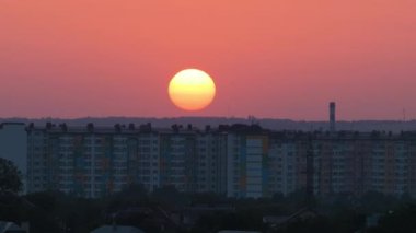 Güneş batarken akşam manzarası Uzak şehrin yüksek binalarının üzerinde gün batımında.