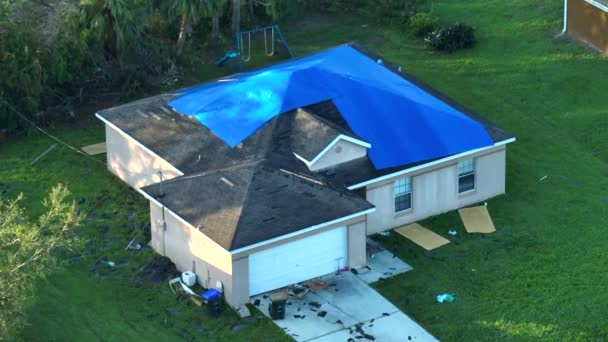 ハリケーンイアンは アスファルトの帯状疱疹の交換まで雨漏りに対する保護プラスチック製のタープで覆われた家の屋上を損傷した 自然災害の余波 — ストック動画