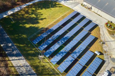 Temiz elektrik enerjisi üretmek için birçok sıra güneş fotovoltaik paneli bulunan sürdürülebilir büyük elektrik santralinin havadan görünüşü. Sıfır emisyon kavramı ile yenilenebilir elektrik.