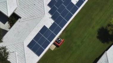 Temiz elektrik üretimi ve dönen havalandırma vantilatörü için çatısı güneş panelleriyle kaplı Amerika 'daki sıradan bir ev. Enerji tasarrufu için özerk eve yatırım yapma kavramı.