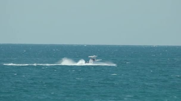 波打つ波の上でスピードボートが速く泳ぐ 高速海上を航行中のモーターボート — ストック動画