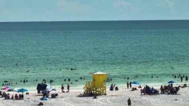 Siesta Key plajının yukarısından Sarasota, ABD 'de turistlerle dolu beyaz kumların görüntüsü. Birçok insan tatillerini Meksika körfezinde yüzerek ve sıcak Florida güneşinde dinlenerek geçiriyor..